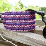 Two point paracord rifle sling. Primary color purple. Secondary color pink camo. Extra wide double cobra weave. Push button quick release swivel and webbing loop connection.