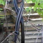 Convertible single point paracord rifle sling. Primary color grey. Secondary color black. Extra wide double cobra weave. Push button quick release swivels.