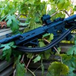 Two point paracord gun sling on a rifle. Primary color grey. Secondary color black. Double cobra weave.