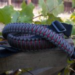 Two point paracord rifle sling. Primary color grey. Secondary color red. King cobra weave. Push button quick release swivels.
