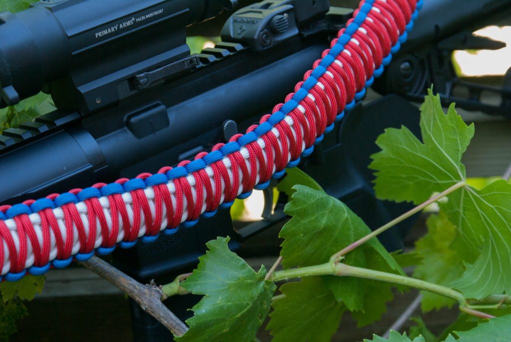 Two point paracord gun sling. King cobra "Old Glory". Red, white, and royal blue. Push button quick release swivels.